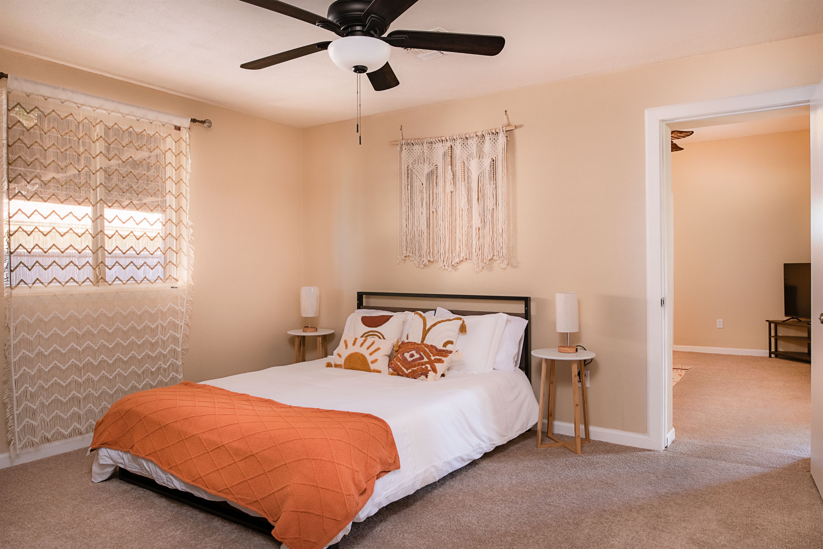 Bright and inviting, this boho-style bedroom features soft natural light, vibrant accent pillows, and direct access to the living area for easy relaxation.
