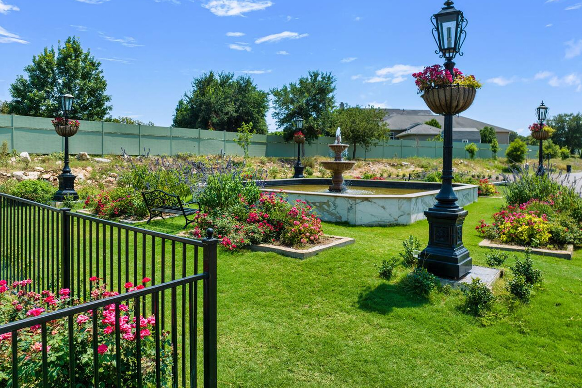 Vintage lampposts and vibrant flower beds line the garden path, creating a picturesque spot for an evening walk.
