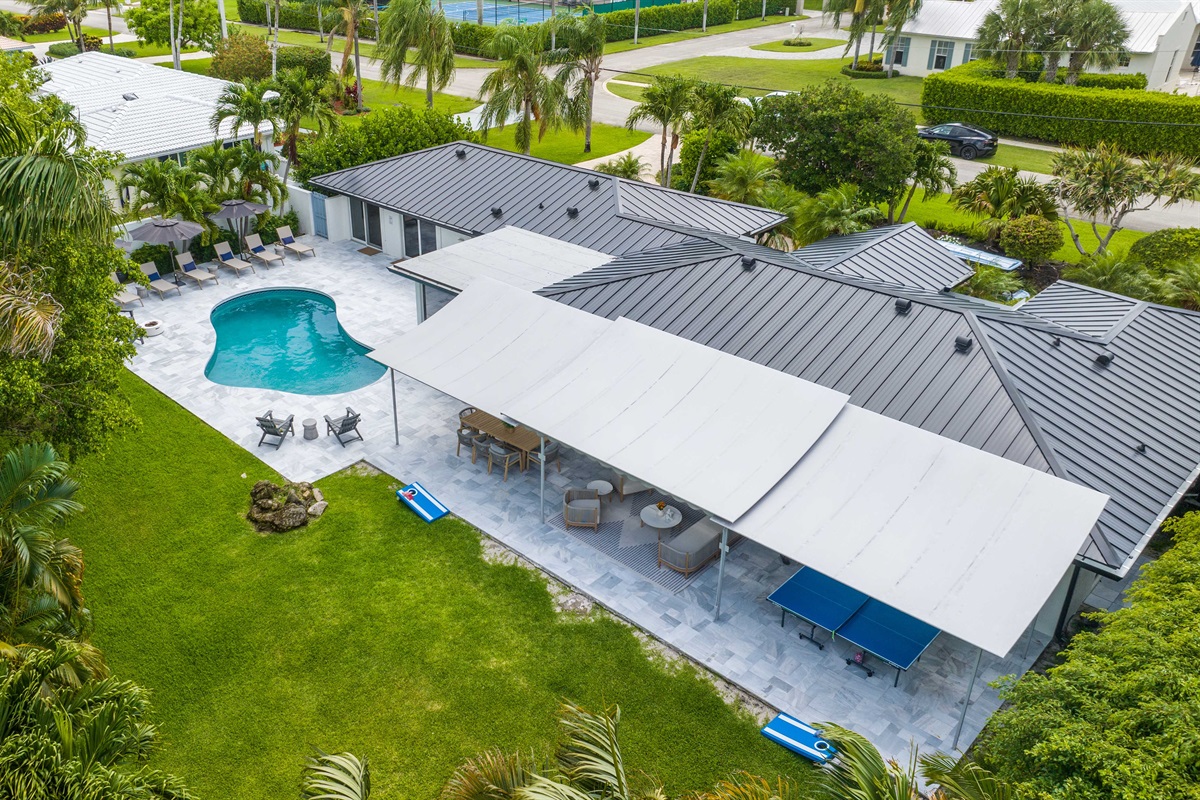 From above, Oasis Palms shows off its private pool, covered patio, open lawn, and tropical setting for a relaxed Delray Beach escape.