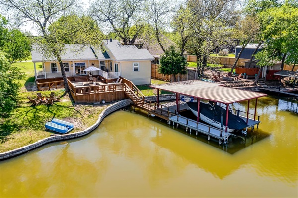 Expansive back deck and private dock with canal access to Lake Granbury — includes paddle boat and space to tie up your boat or jet ski.