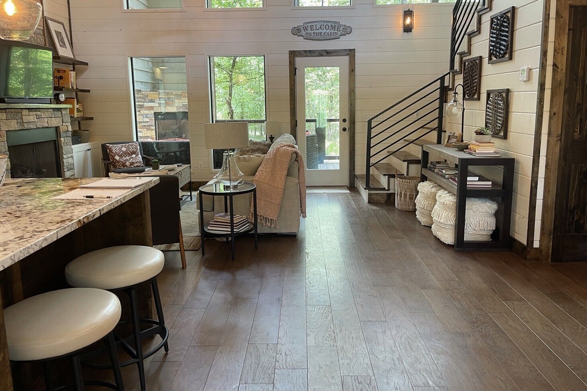 Entry way view of the cabin. Dining area is on the right, the fully-equipped kitchen on the left. Large wall of windows on the back overlooking the Ouachita National Forest.