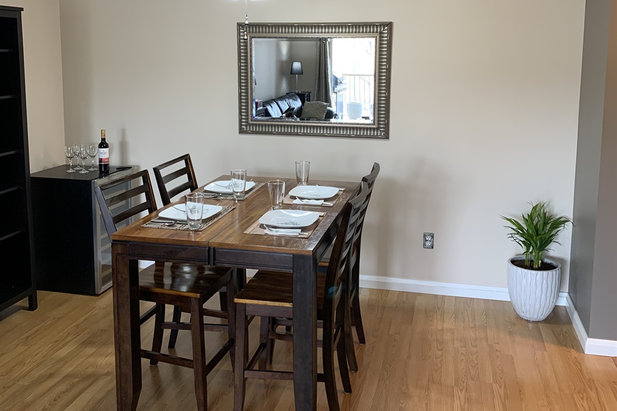 Spacious dining room with large table. Place setting for 4 guests.