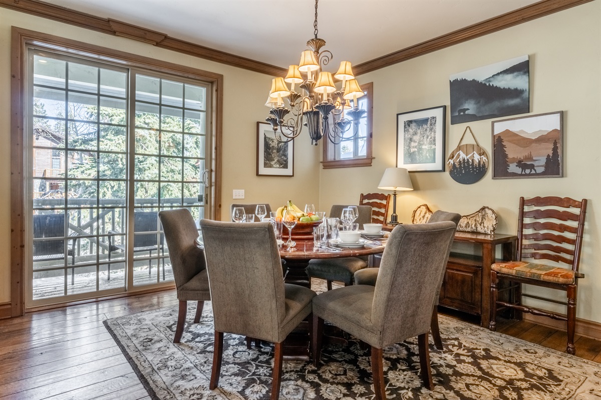 Round dining table set beside floor-to-ceiling windows, filling the space with natural light.
