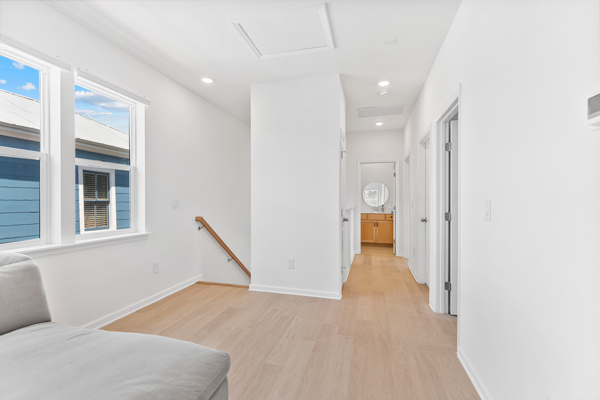 The upstairs landing, bright and easy, with bedrooms and baths just off the hall. Laundry tucked around the corner means you can wash the day away and start fresh, everyone close, everyone with their own corner.