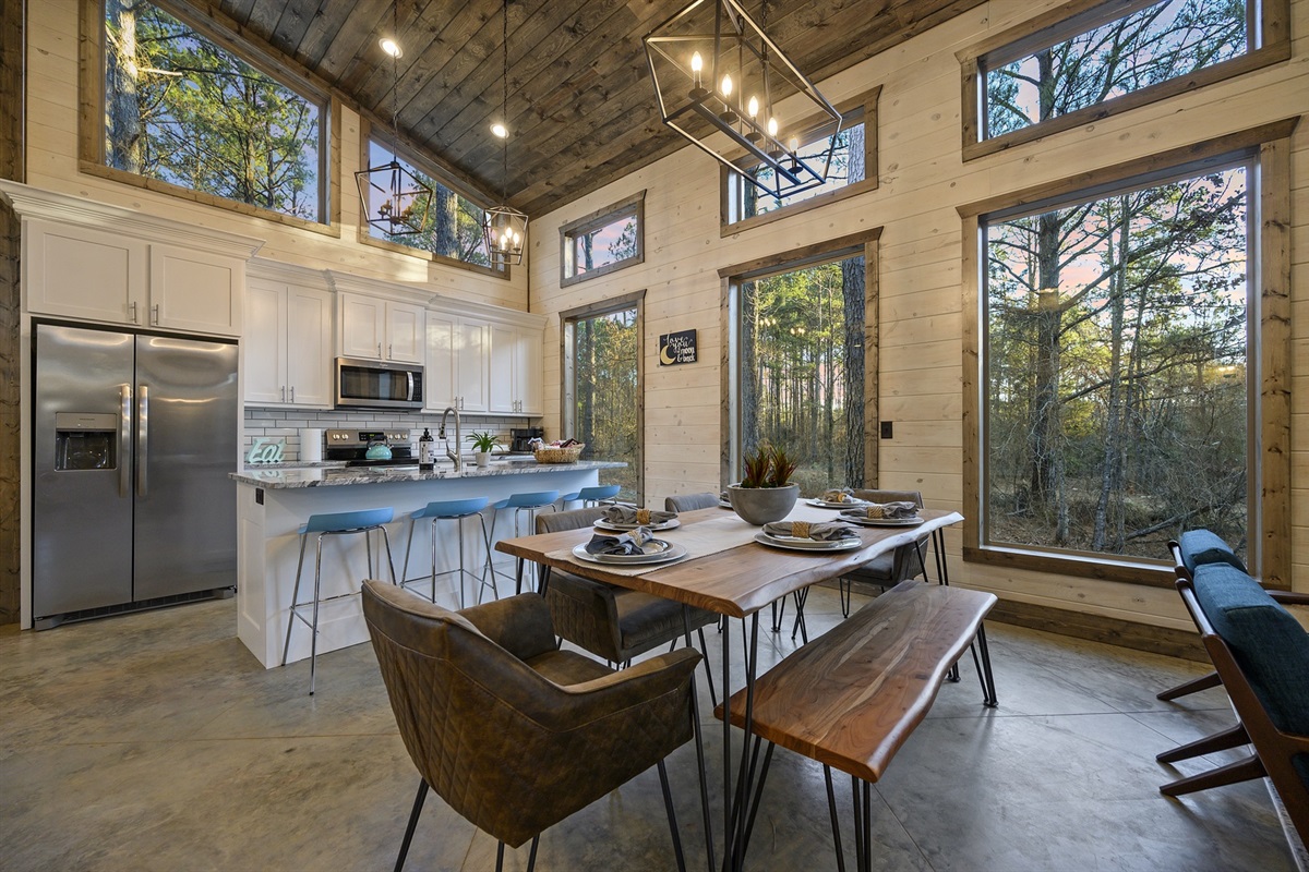 Bright windows frame the trees while you cook and connect. It is the kind of kitchen that makes pancake mornings and charcuterie nights feel simple and special.