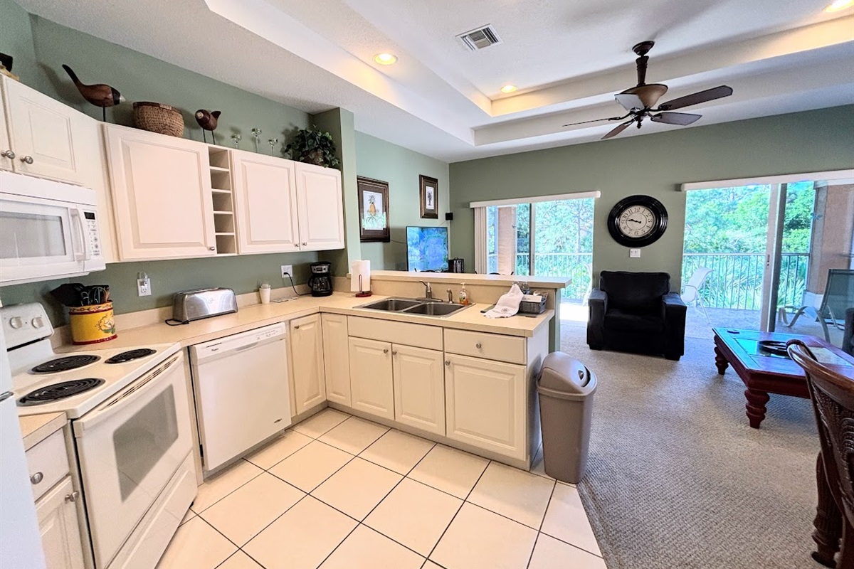 Bright open kitchen and living space with high ceilings, full-size appliances, and easy access to the main living area.