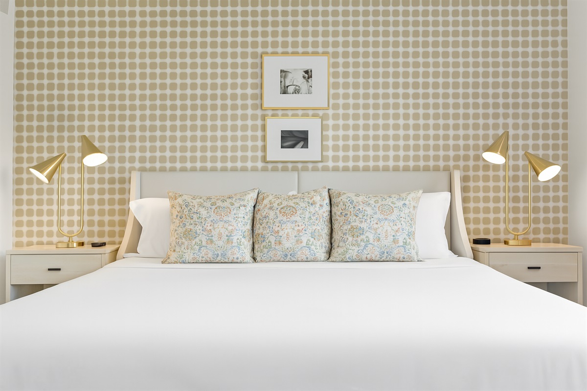 Comfort meets design in this cozy king bedroom featuring a statement accent wall and soft lighting.
