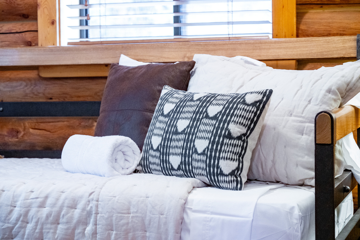 Comfortable twin bed dressed for a restful night after a day in the mountains.