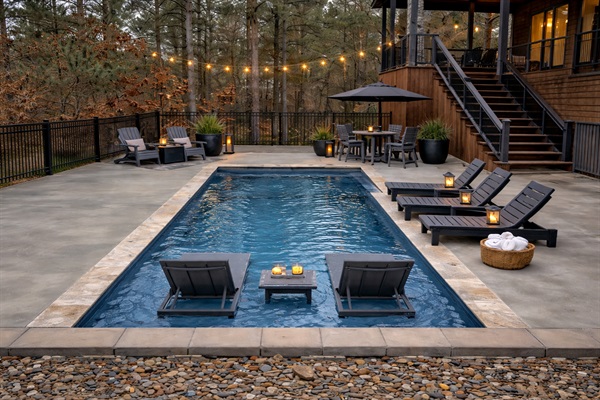 Outdoor Oasis is finally here: Dive into relaxation with a stunning pool, lounge chairs, and serene forest views all while keeping drinks cool in provided table ice chests