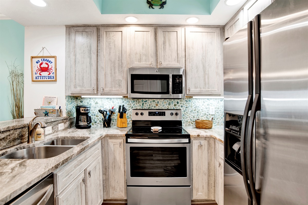 Kitchen with stainless appliances, granite countertops, tiled backsplash and great Gulf view