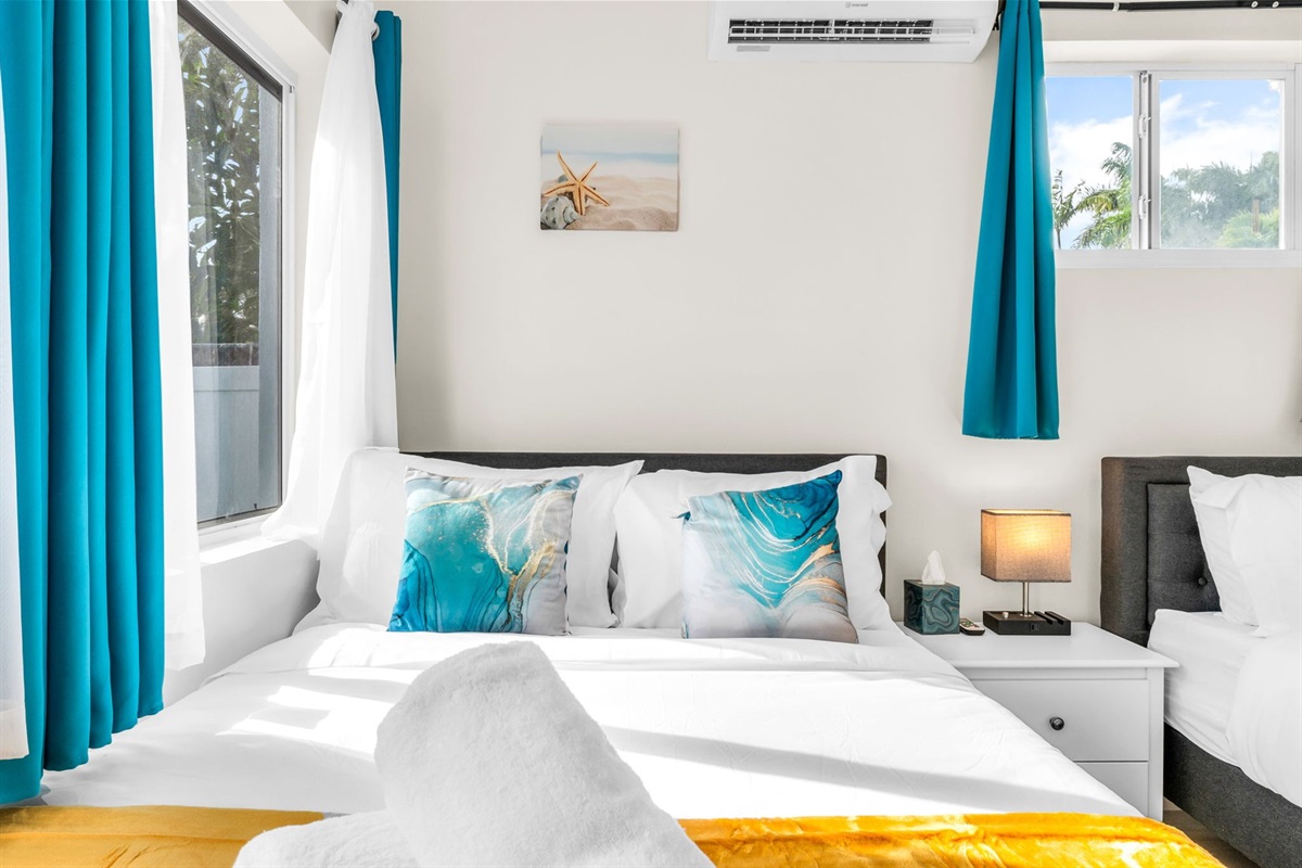 Relax in the sunny 4th bedroom—complete with two full-size beds, coastal décor, and a freshly updated ensuite bathroom.