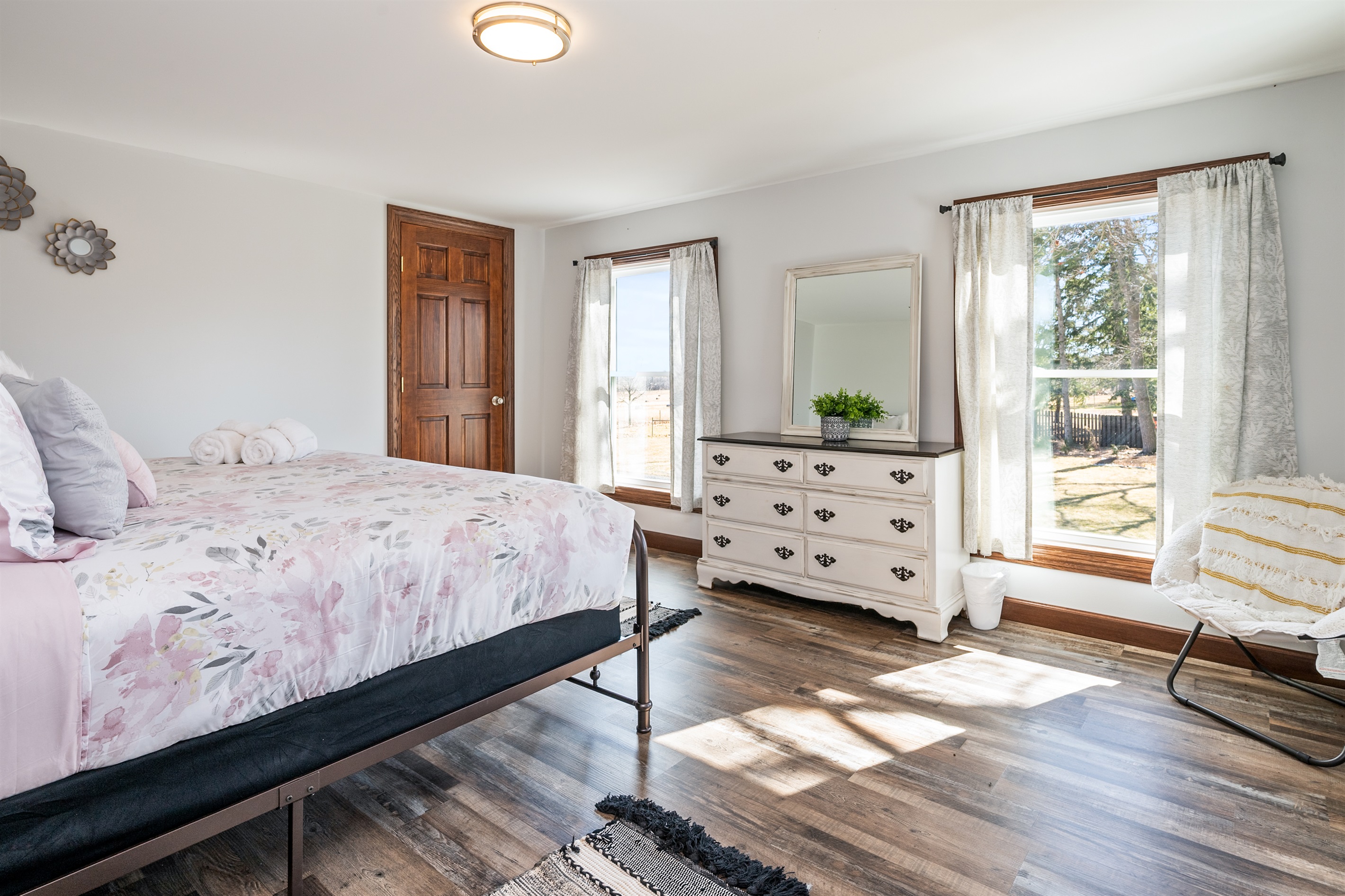 Spacious bedroom with large windows, a comfy queen bed, and a calm, airy design that creates the perfect retreat for rest and rejuvenation.