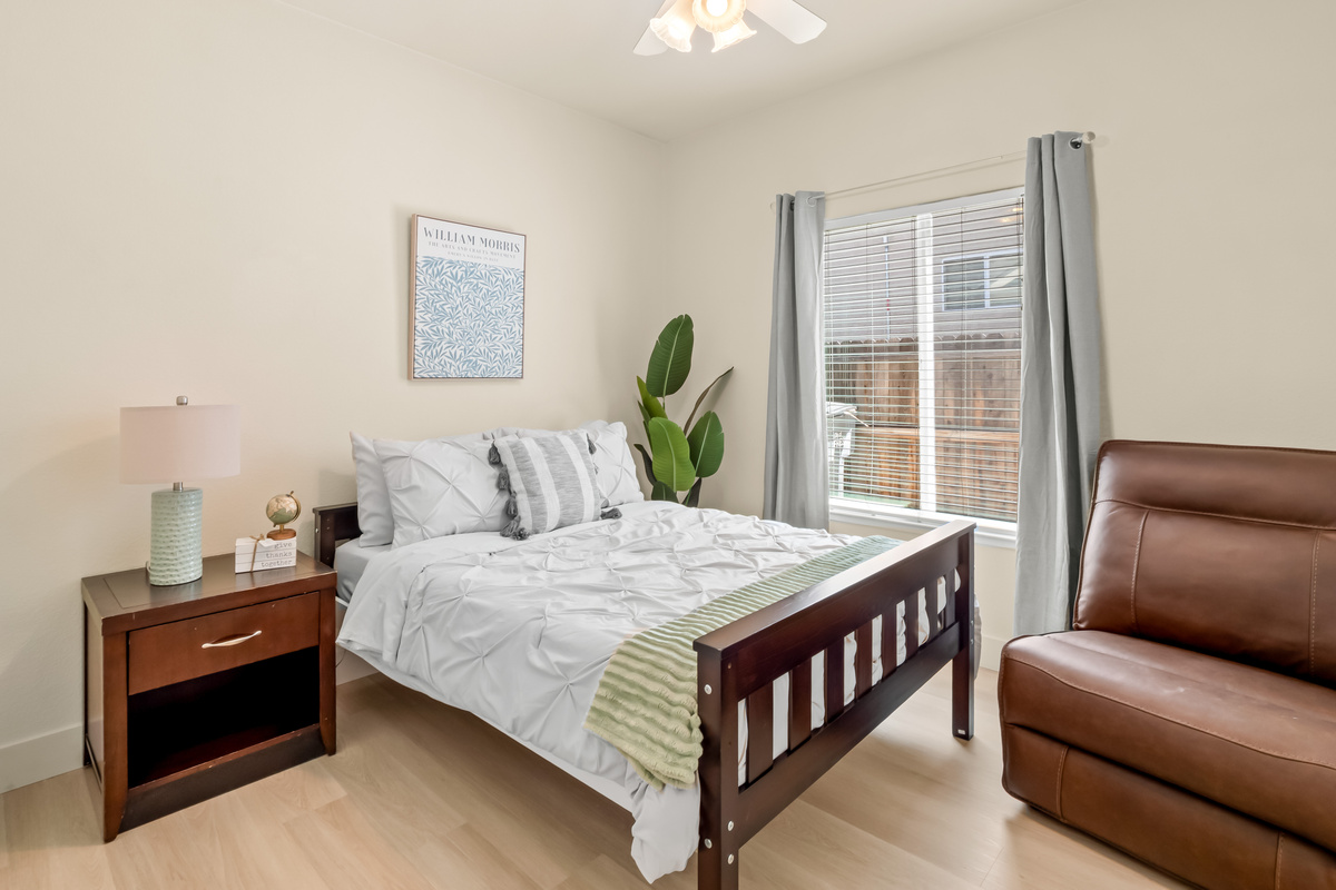 Recharge in this peaceful and comfortable bedroom featuring a cozy bed, soft bedding, and thoughtful touches throughout. Natural light and calming décor create the perfect environment for a restful night's sleep.