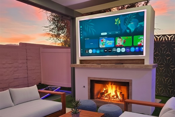 Cozy outdoor living area with fireplace and 75 inch 4k tv.