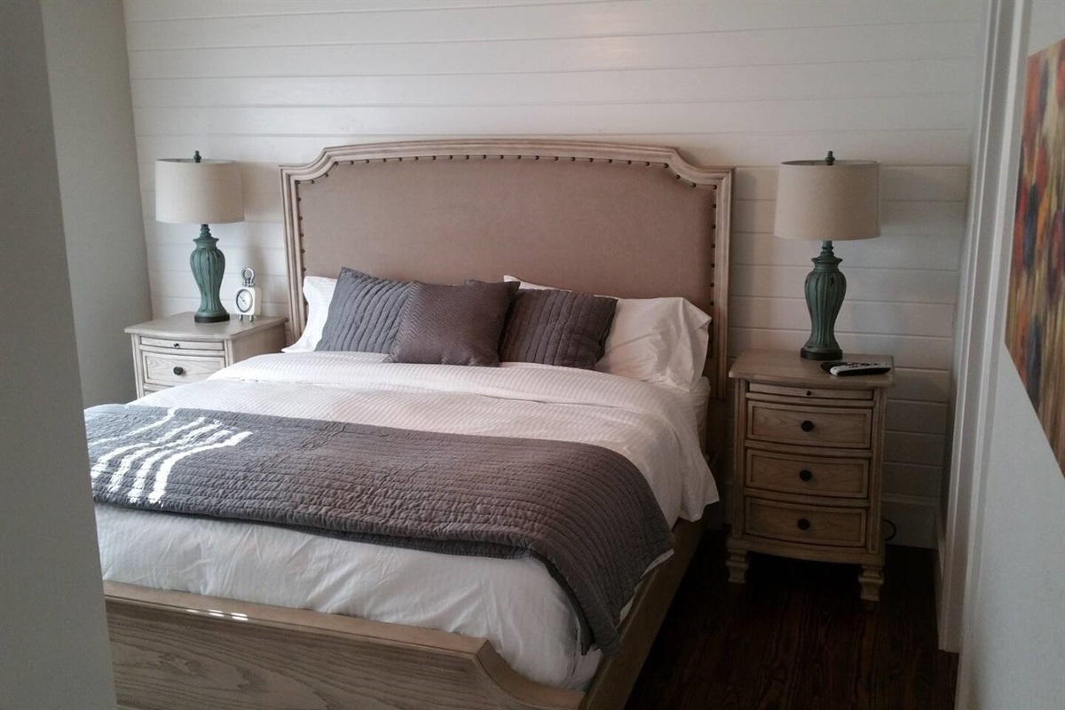 King-size bed in downstairs bedroom of cabin rental in arkansas