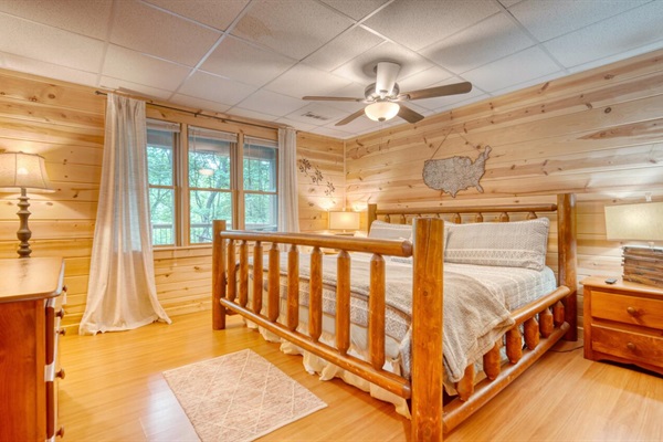 Downstairs bedroom with king bed, smart tv, and view of the creek