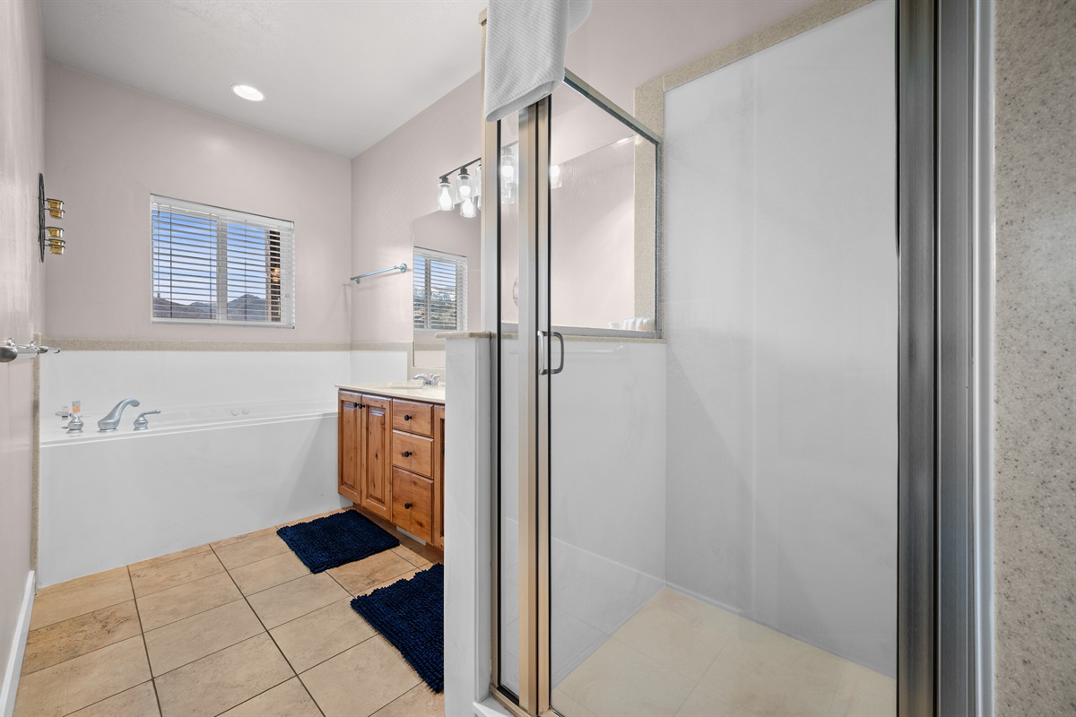 Primary bathroom featuring a soaking tub and glass-enclosed shower.