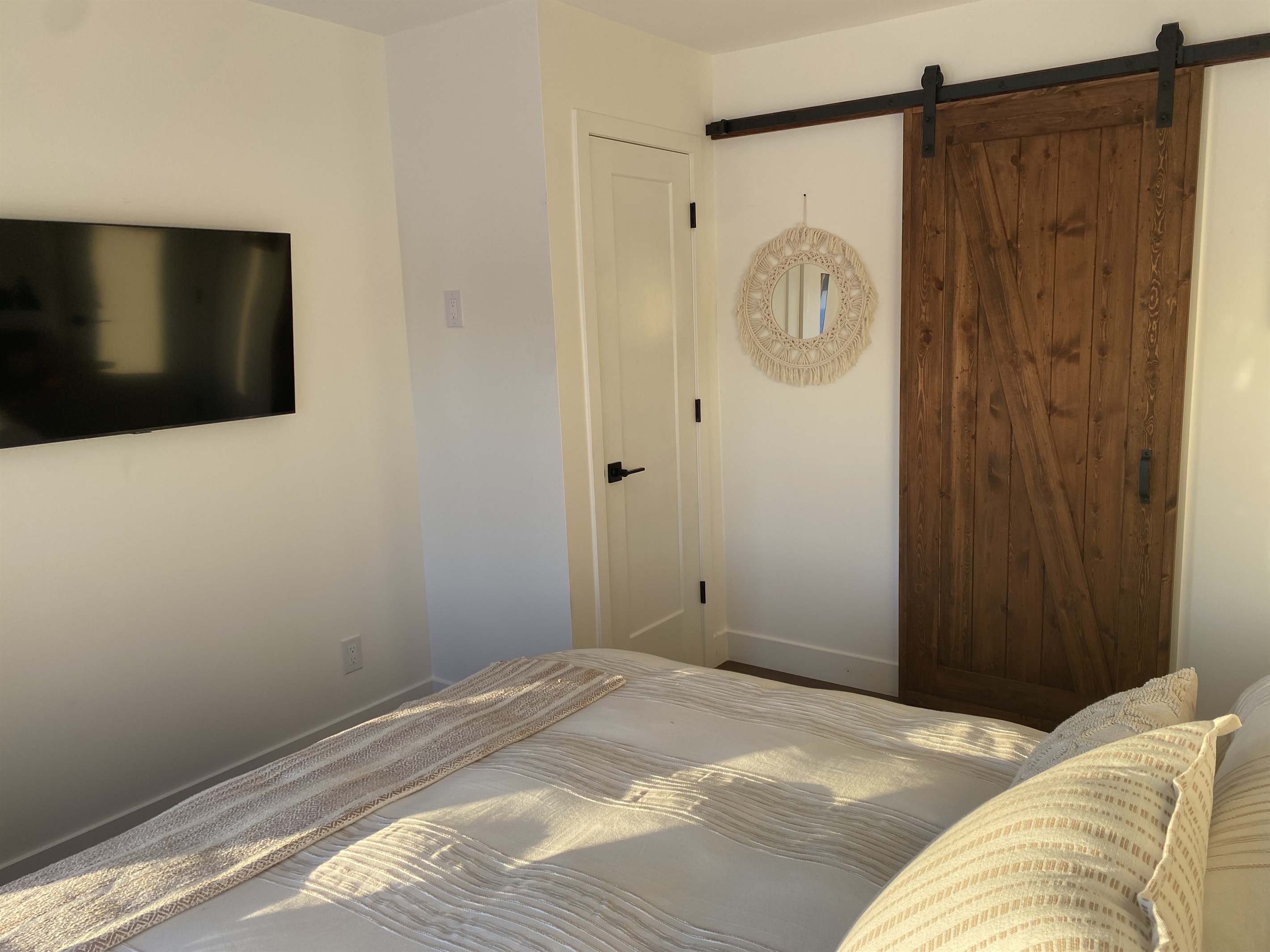 Main level bedroom showing sliding door entry to ensuite full bathroom and closet door