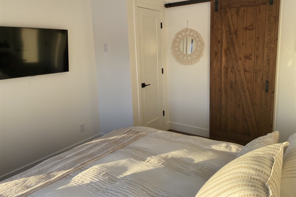 Main level bedroom showing sliding door entry to ensuite full bathroom and closet door