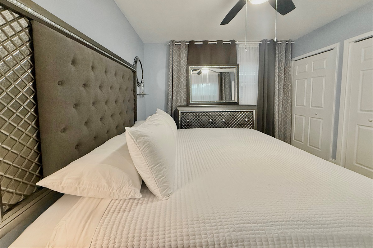 Sleep like royalty in this beautifully appointed room with a luxurious king bed, plush linens, and chic mirrored accents.