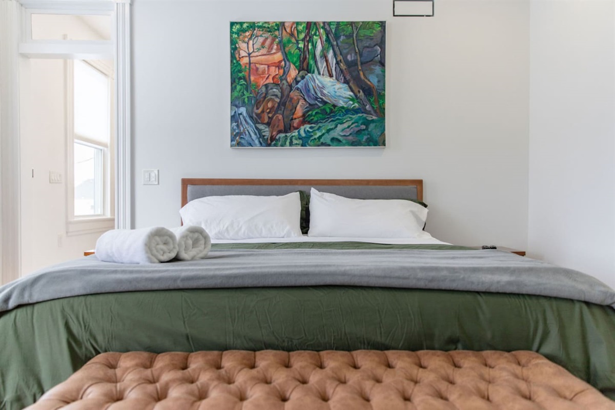 A cozy bedroom featuring a comfortable queen-sized bed, dressed in soft linens and placed as the focal point of the room, offering a perfect spot for rest and relaxation.