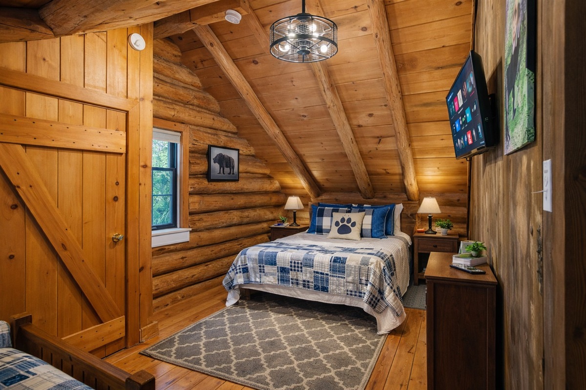 Cozy log cabin bedroom with rustic charm, soft lighting, and a comfy queen bed—perfect for a restful mountain retreat.
