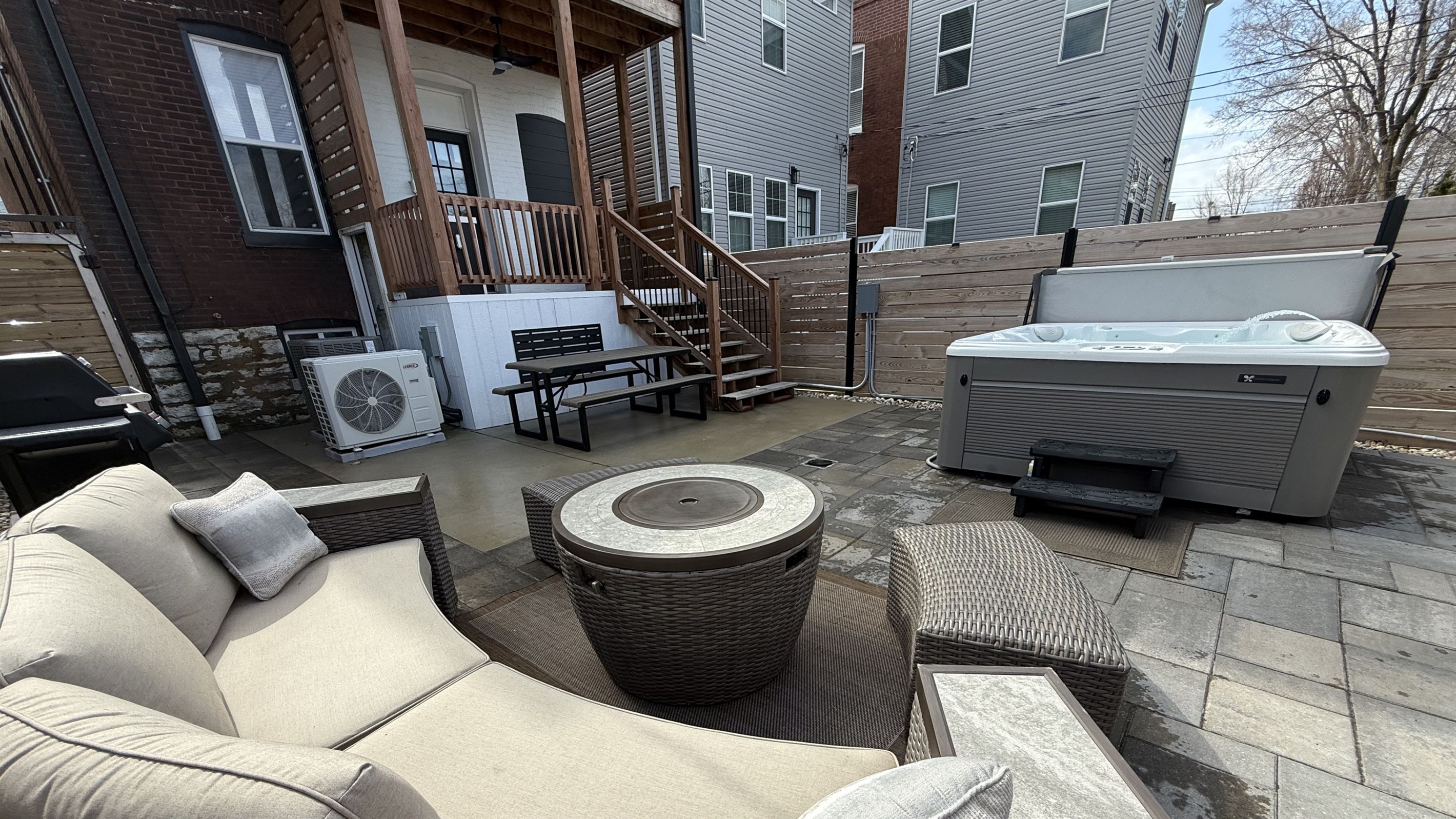 Enjoy a private backyard retreat featuring a 6-seater hot tub, gas grill, picnic table and plenty of lounge seating with a center fire table.