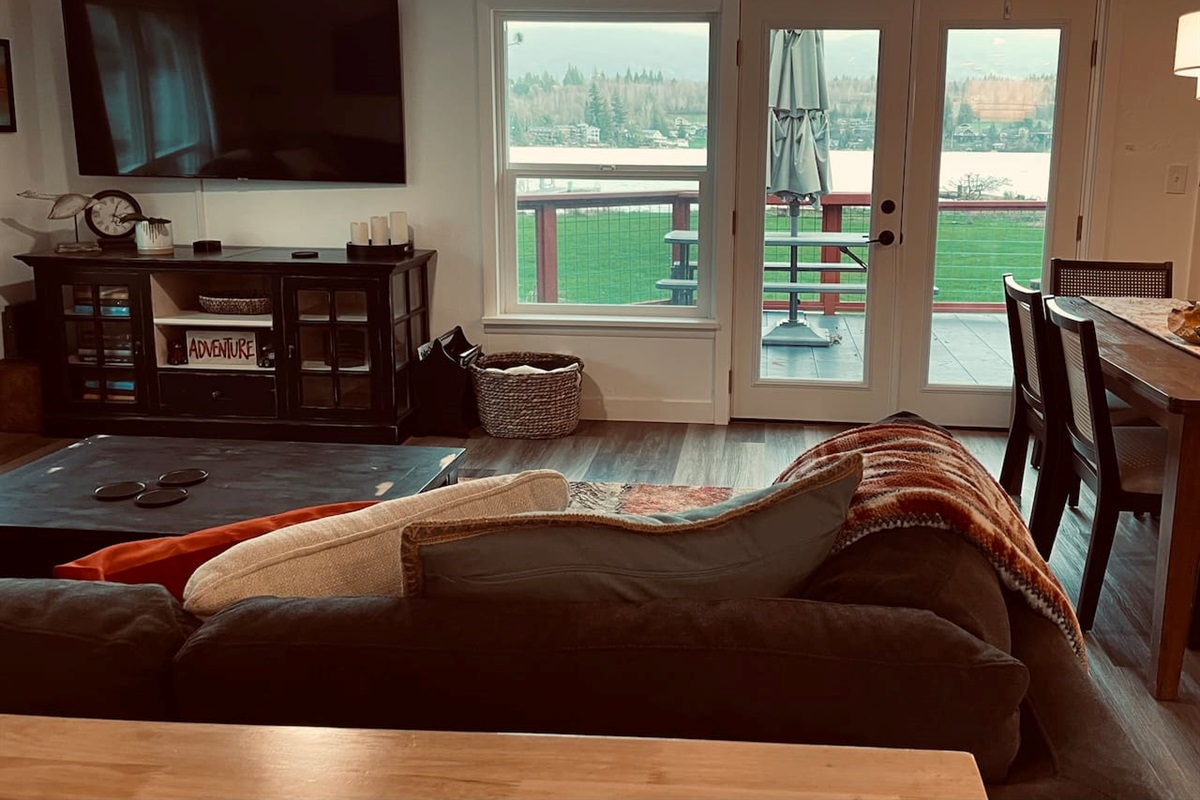 A cozy living space with a TV, where the view stretches across the lake, bringing calm and connection to the room.