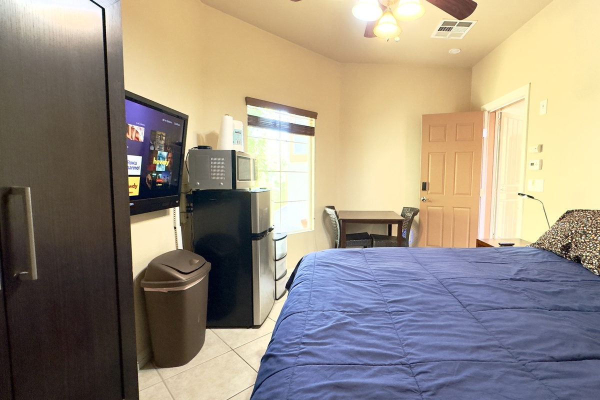 Cozy furnished studio — table, seating, and private entrance with smart lock