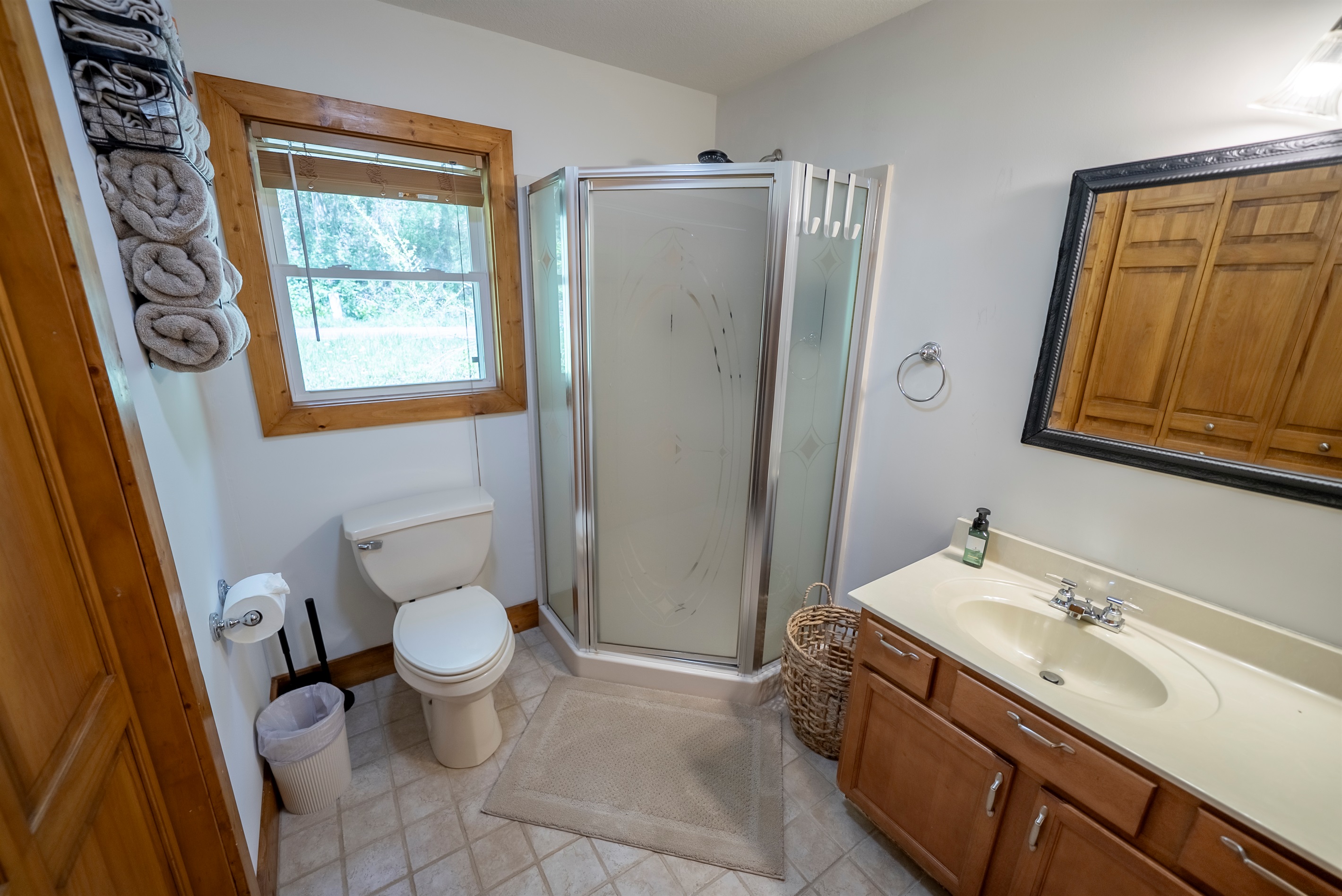 Guest bathroom with a stand-alone shower, vanity, and in-unit laundry for added convenience.