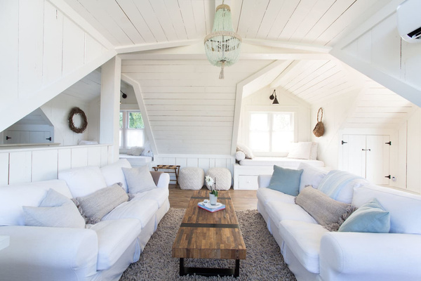 Hand-hewn wood-paneled walls and tucked-away nooks give this upstairs retreat its soul. One of two living rooms, it offers cloud-soft sofas, quiet reading corners and plenty of room to stretch out beneath the eaves.