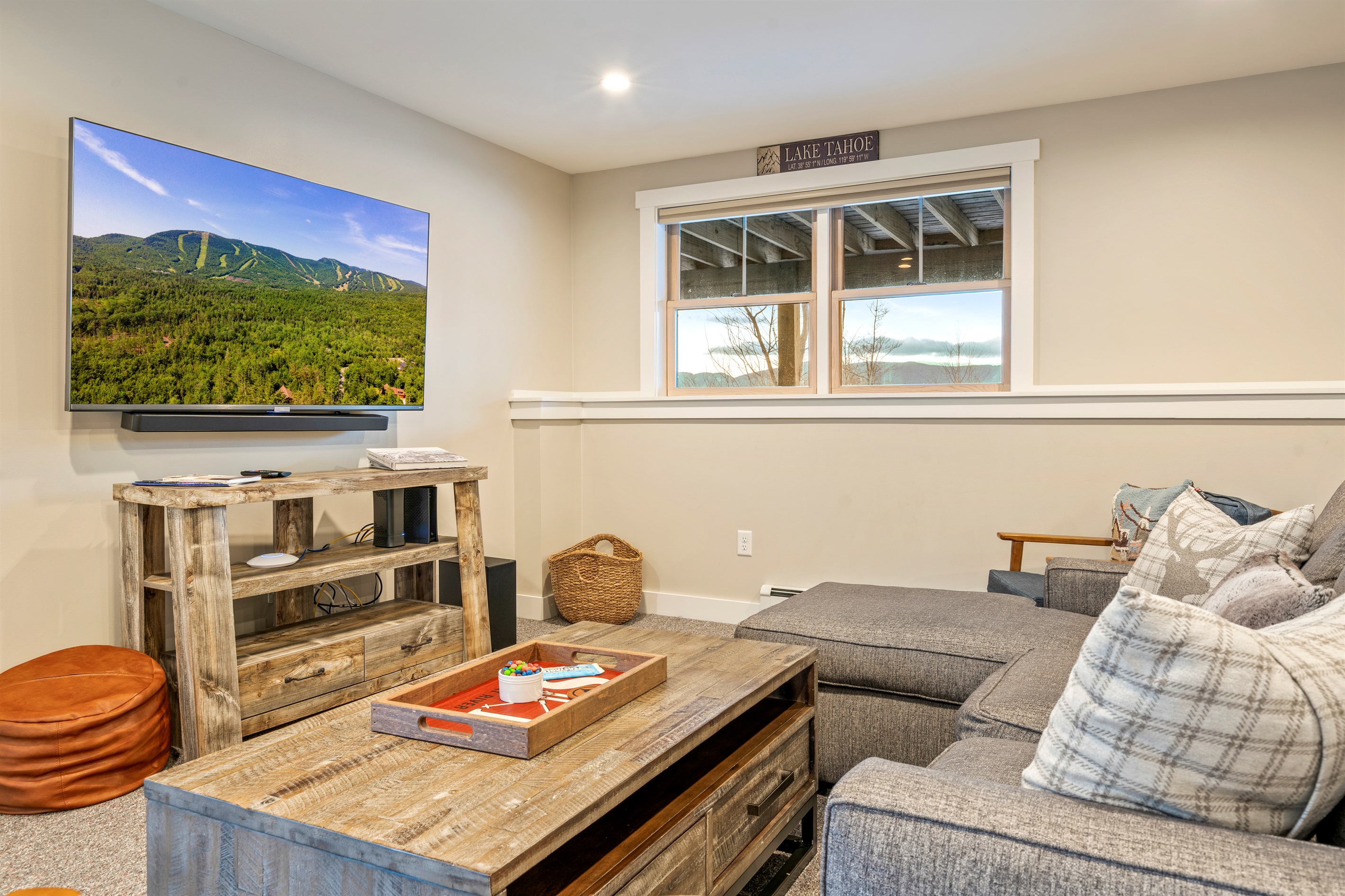 Basement game room featuring a cozy lounge and large TV for movie nights.