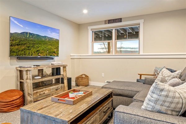 Basement game room featuring a cozy lounge and large TV for movie nights.