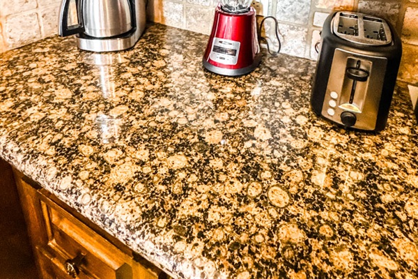 Full kitchen with coffee maker, toaster, blender, and bar seating.