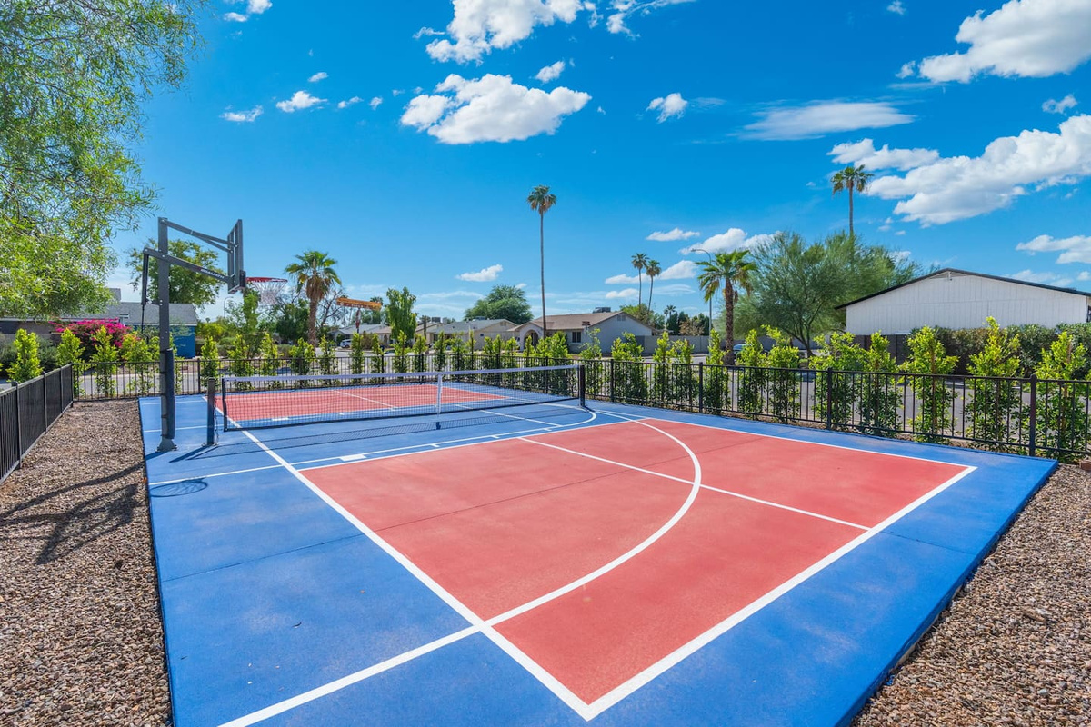 Community sports court with basketball and tennis facilities overlooking manicured grounds.