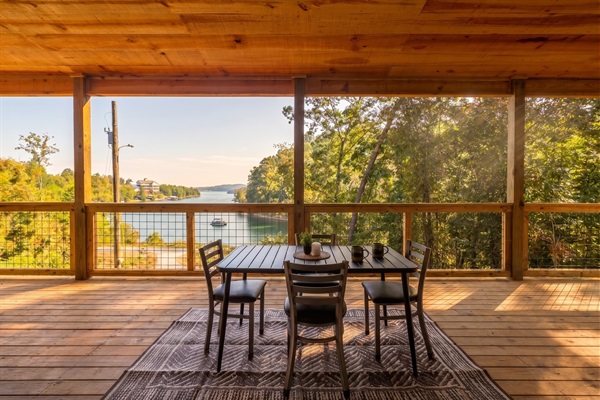 Covered wrap-around porch with outdoor dining and open Douglas Lake views, morning coffee and sunset dinners without leaving the deck.
