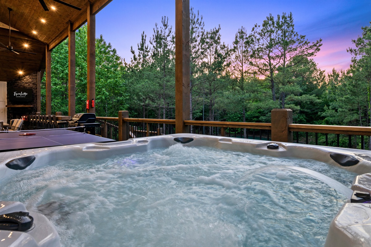 The bubbling hot tub creates the perfect place to recharge and relax while taking in the peaceful wooded views and colorful evening skies.