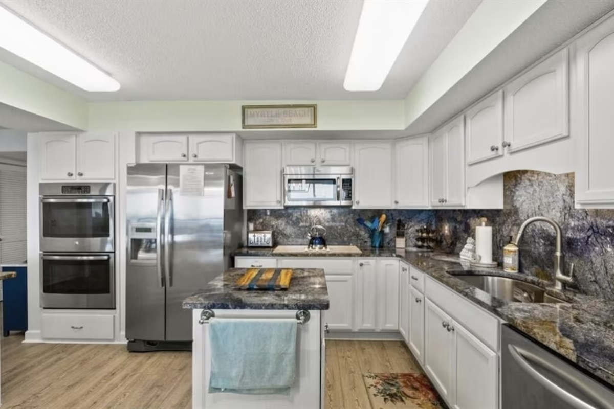 The kitchen is features a large island, gorgeous granite countertops, and is equipped with everything you need, including a double oven!