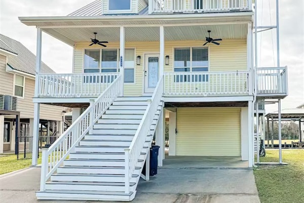 Charming elevated beach home with wraparound porches, covered parking, and breezy outdoor spaces