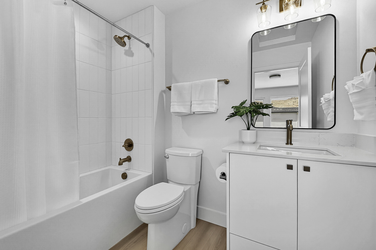 3rd floor bedroom with queen size bed ensuite bathroom with tub/shower combination and single sink vanity