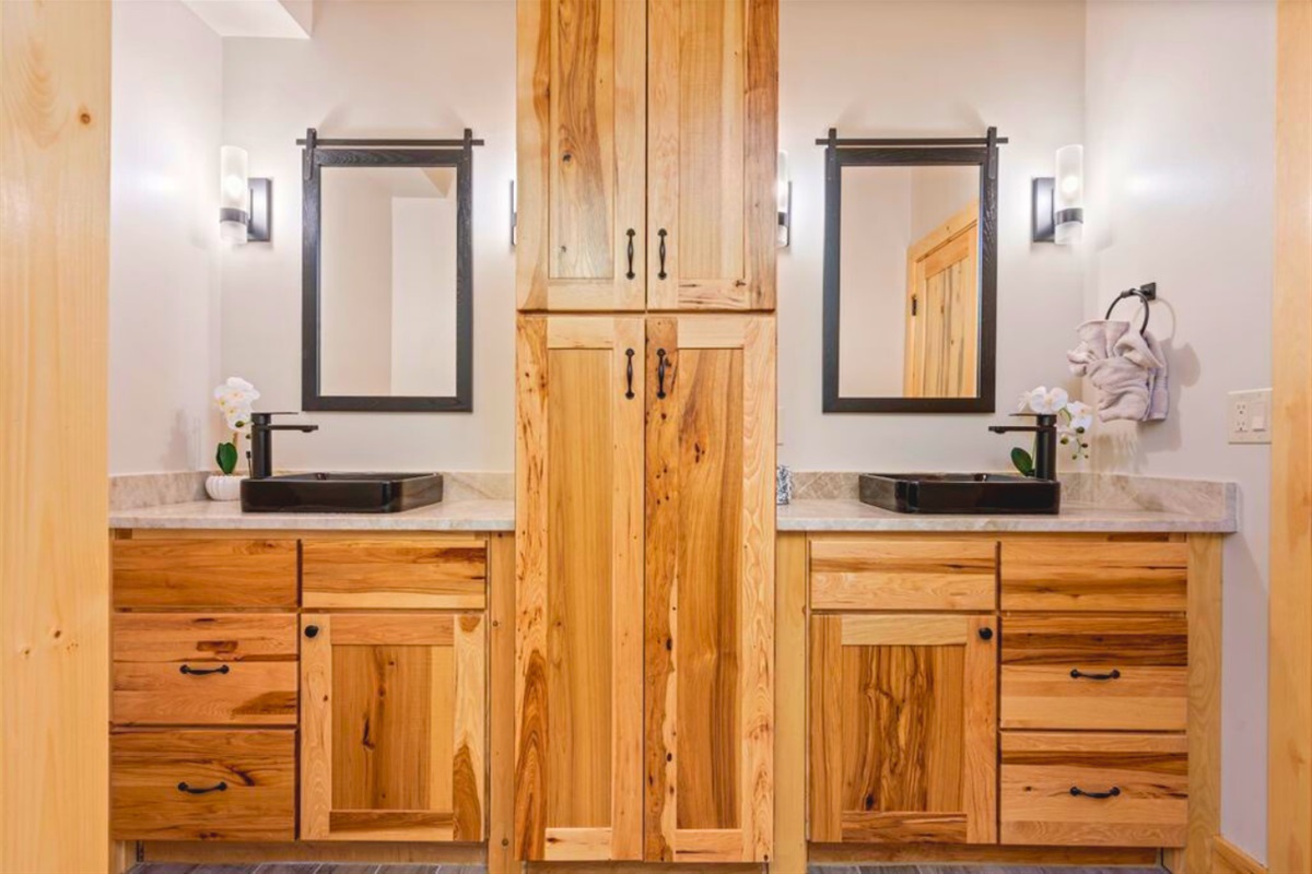 Shared bathroom in the basement with tub/shower and double sinks.