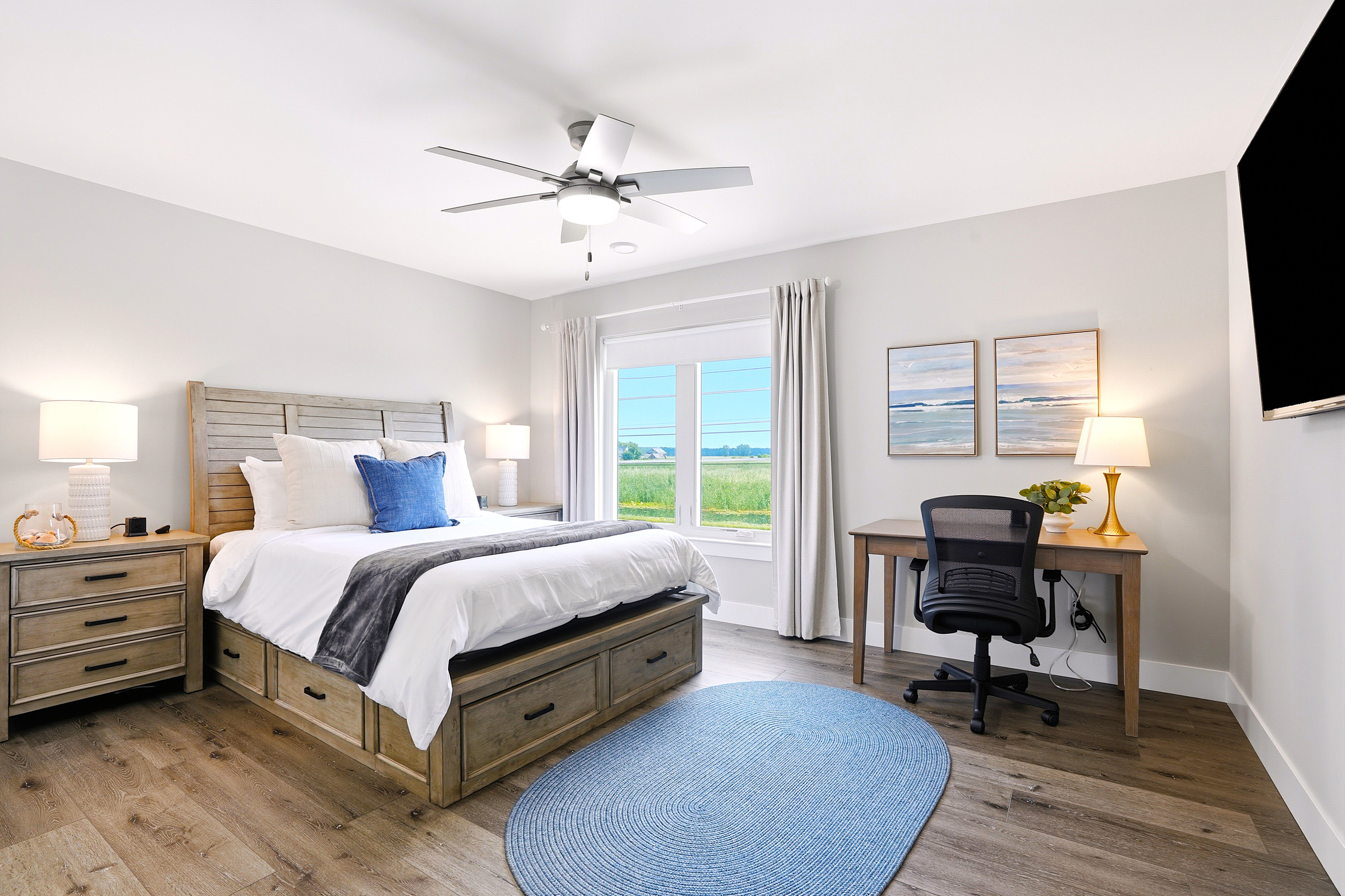 Unwind in this inviting second-floor bedroom, featuring a comfortable queen bed, peaceful natural light, and thoughtful amenities designed for a relaxing stay.
