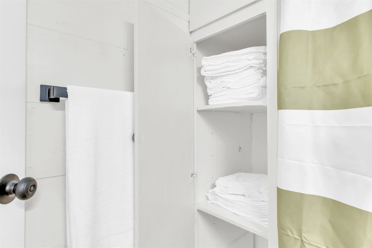 Bathroom with shower/tub combo, fresh linens, and hotel-style touches.