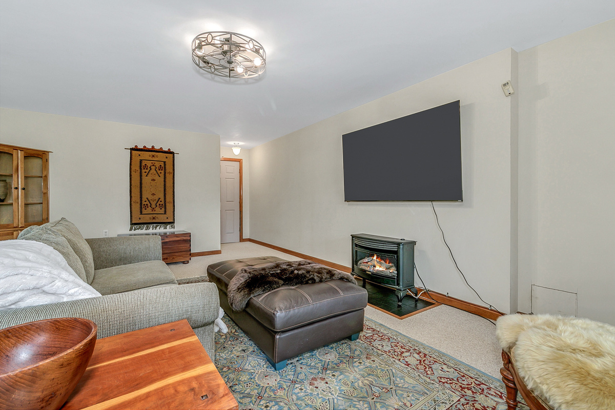 Basement Entertainment Room with Large Smart TV and Gas Fireplace