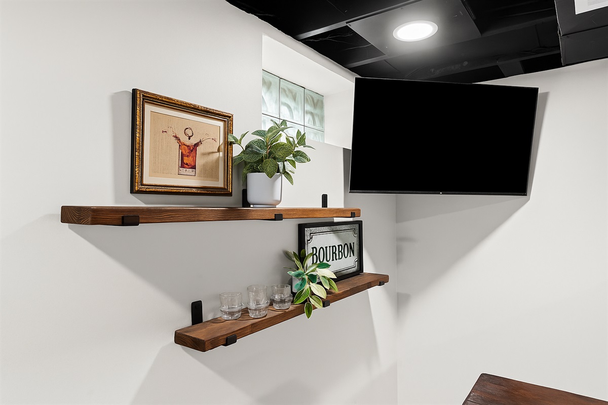 Chic bar shelves with stylish decor and Smart TV—perfect for sipping and streaming.