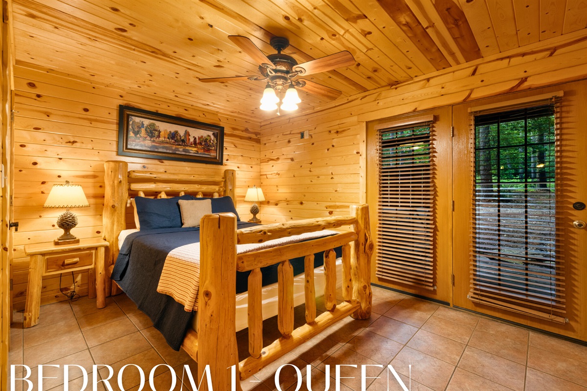 Bedroom 1 with queen log bed and deck access.
