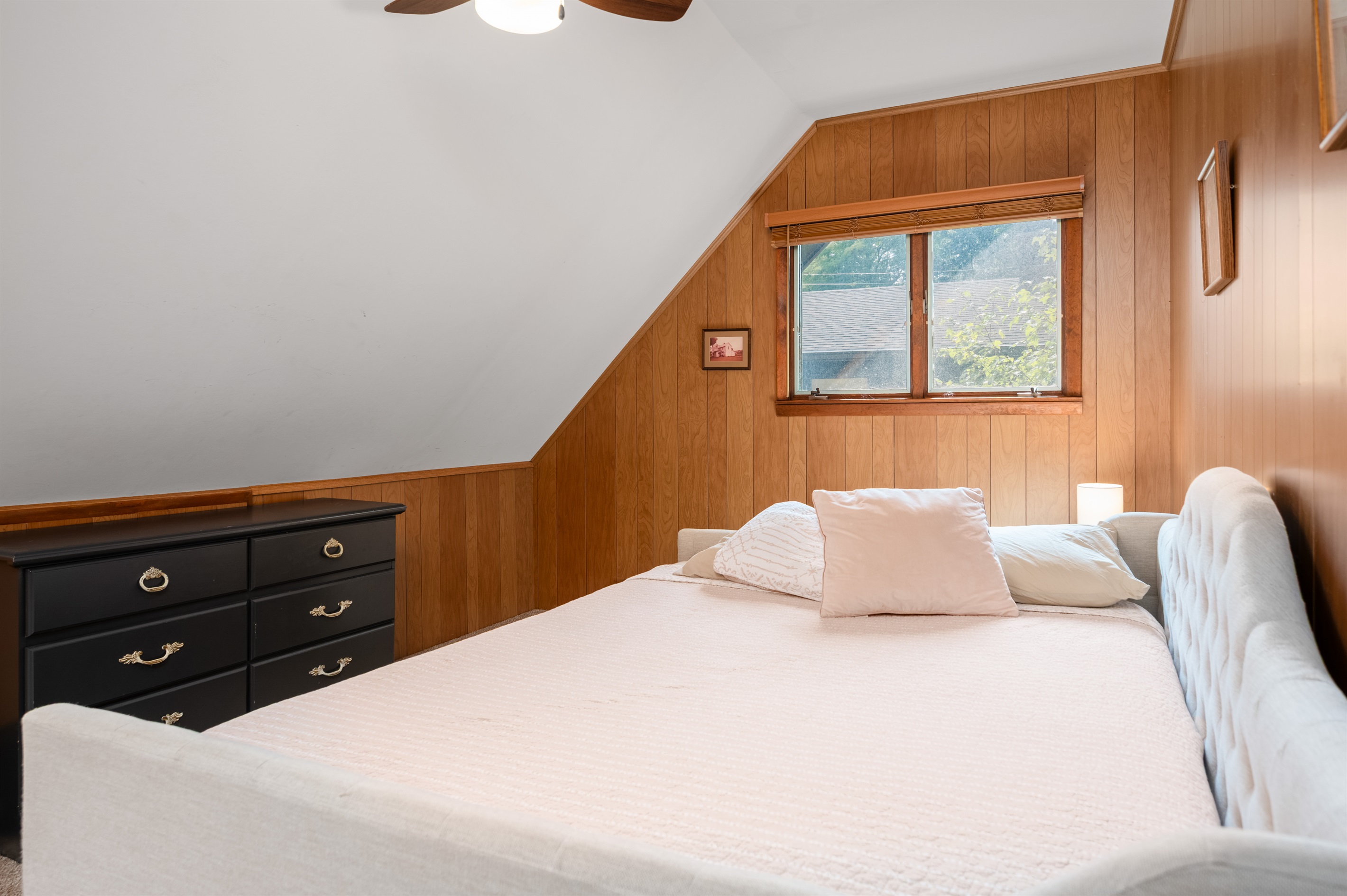 Upstairs bedroom with full bed and sloped ceiling charm
