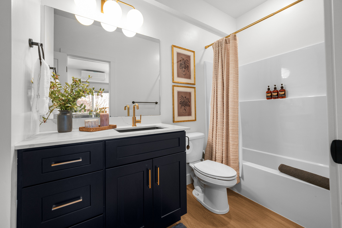 A bright full bathroom with a spacious vanity and clean, modern finishes.