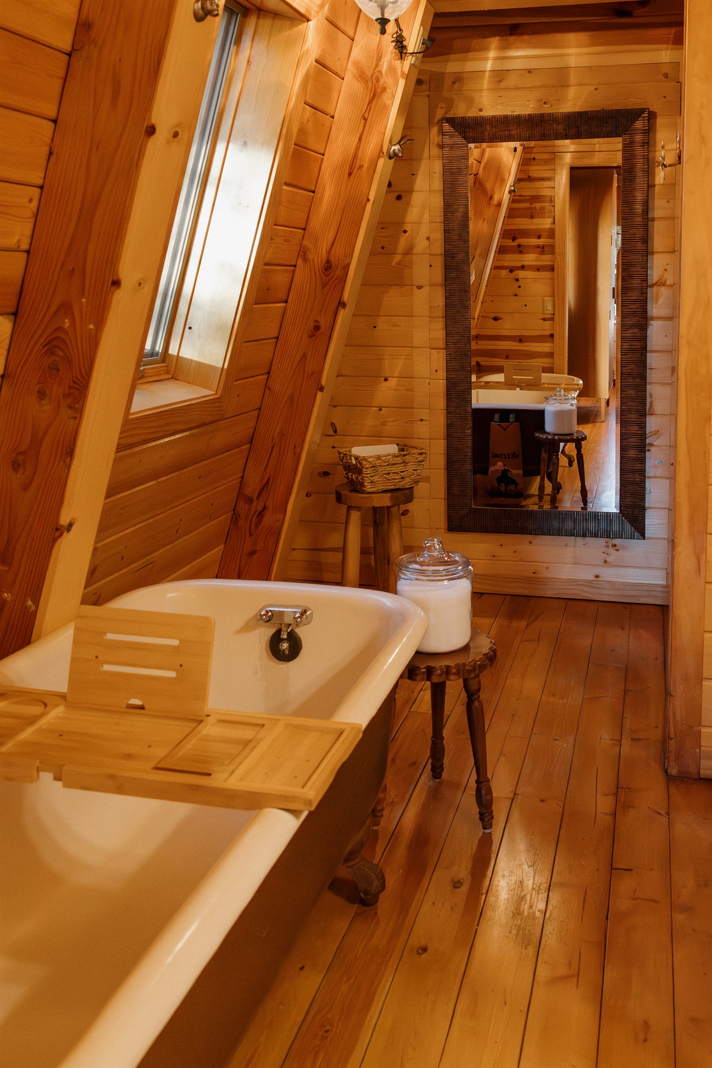 The spa-like bathroom at Poppywood Pines features a clawfoot tub, skylight, and full-length mirror. This gothic western Show Low A-frame offers luxurious comfort with rustic charm, perfect for unwinding after White Mountains hiking, fishing, and adventures