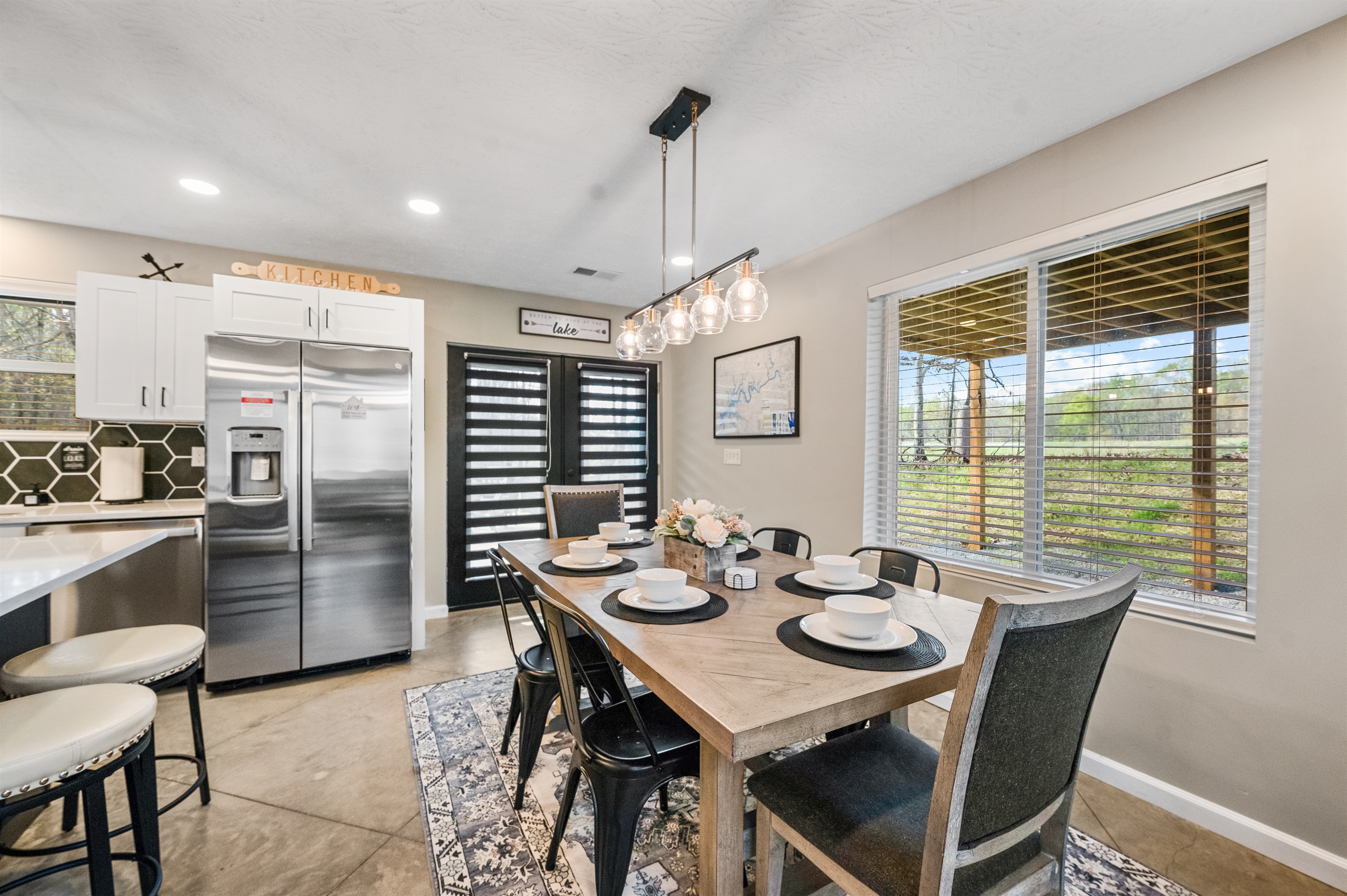 Enjoy meals with a view—the dining table sits beside a large window overlooking the peaceful cow pasture, with two extra seats available at the kitchen island.